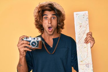 Elinde klasik kamera ve şehir haritası olan İspanyol genç adam şaşkınlık ve şaşkınlık ifadesi, korku ve heyecan dolu yüz ifadesiyle dehşete düşmüş ve şok olmuştu.. 