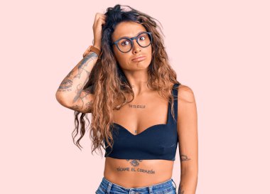 Sıradan kıyafetler ve gözlük takan İspanyol bir kadın soru sorup kafasını karıştırıyor. Şüpheyle kararsız, kafa kafaya düşünerek. Düşünceli kavram. 