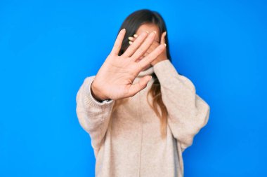 Kışın yün kazak giyen, elleriyle gözlerini kapatan, üzgün ve korku ifadeleriyle jest yapan güzel beyaz bir kadın. utangaç ve olumsuz kavram. 