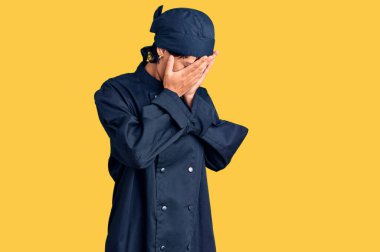 Kısa saçlı genç esmer kadın profesyonel aşçı üniforması giyiyor. Ağlarken yüzünü ellerle kapatıyor. depresyon kavramı. 