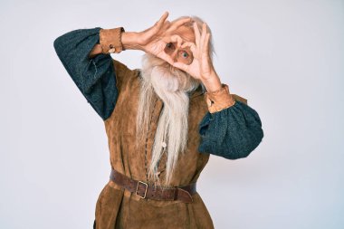 Gri saçlı, uzun sakallı, Viking kostümü giyen, kalbi el ve parmaklarıyla şekillendiren, tabeladan bakıp gülümseyen yaşlı bir ihtiyar. 