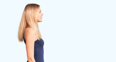 Genç, güzel, sarışın bir kadın, rahat bir görünüm arıyor, rahat bir görünüm takınıyor, kendine güvenen bir gülümsemesi var.. 