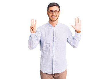 Zarif iş gömleği ve gözlük takan yakışıklı genç adam sekiz numarayı gösterip işaret ederken kendinden emin ve mutlu bir şekilde gülümsüyor.. 