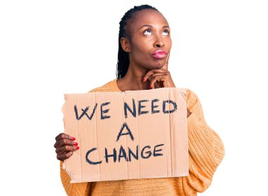 Genç Afro-Amerikalı bir kadının elinde bir değişim pankartı olmalı. Ciddi bir yüz. Çene ve çene üzerine soru sormayı düşünmeliyiz. 