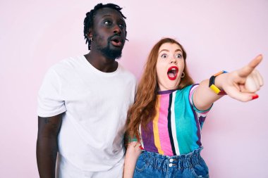 Irklar arası giysiler giymiş, parmakları önde, ağzı açık, şaşırmış, ön tarafta bir şey var. 