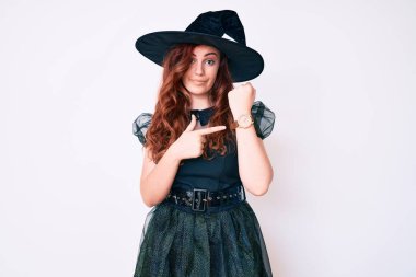 Cadıların cadılar bayramı kostümü giymiş genç ve güzel bir kadın. Aceleyle saati, sabırsızlığı ve rahatlamış bir ifadeyle kameraya bakıyor. 