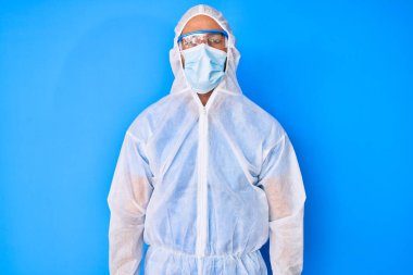 Doktor Coronavirus üniforması giyen genç İspanyol bir adam. Yüzünde ciddi bir ifade var. Basit ve doğal bir şekilde kameraya bakıyorsun.. 