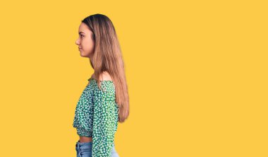 Tişört giyen genç ve güzel bir kız. Taraf arıyor, rahat bir poz veriyor. Kendine güvenen bir gülümsemesi var.. 