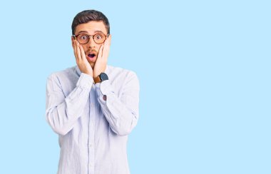 Zarif iş gömleği ve gözlük takan yakışıklı genç adam. Korkmuş ve şok olmuş. Şaşırmış ve şaşırmış. 