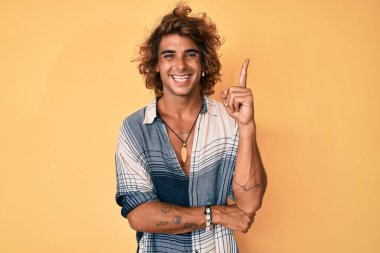 Yaz stili giyinmiş genç İspanyol adam gülümsüyor. 