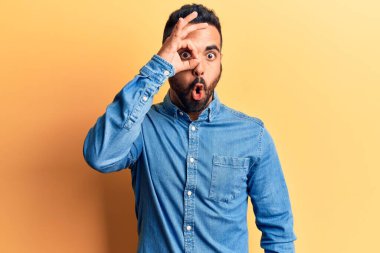 Gündelik kıyafetler giyen genç İspanyol adam şaşırmış yüz ifadesiyle şok olmuş, parmaklarından bakan gözler. İnançsız ifade. 