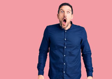 Gündelik tişört giyen genç ve yakışıklı bir adam şaşkınlık ve şaşkınlık dolu bir ifade, korku ve heyecan dolu bir yüz.. 