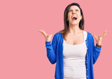 Genç ve güzel bir kadın gündelik kıyafetler giyip deli gibi bağırıyor ve agresif bir ifade ve kollarla bağırıyor. hüsran kavramı. 