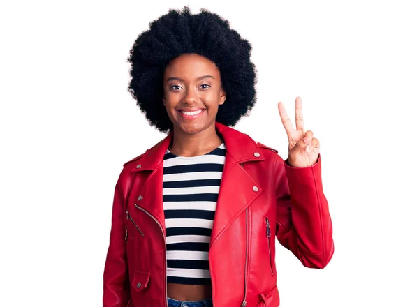 身穿红色皮夹克的年轻的非洲裔美国女人高兴地微笑着 在镜头前眨眼示意胜利 第二点 — 图库照片