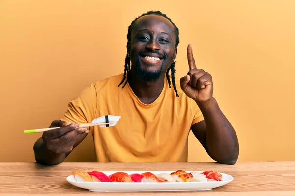 Guapo Joven Negro Comiendo Sushi Sentado Mesa Sonriendo Con Una —  Fotos de Stock