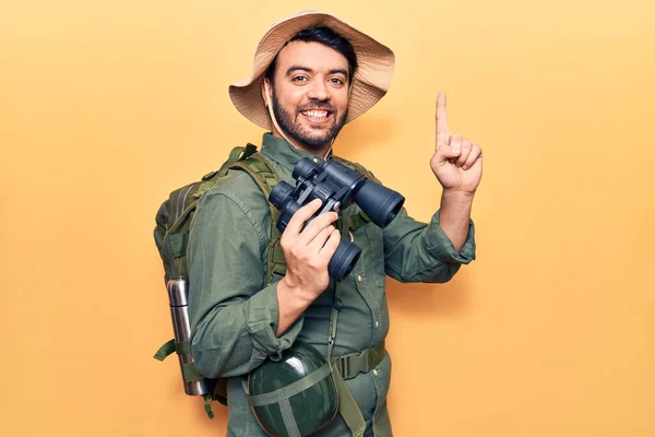 Jovem Hispânico Vestindo Roupas Explorador Segurando Binóculos Sorrindo Com Uma — Fotografia de Stock