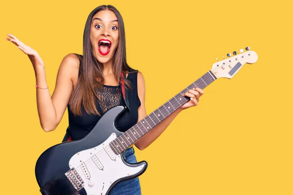 Joven Mujer Hispana Tocando Guitarra Eléctrica Celebrando Victoria Con Sonrisa —  Fotos de Stock