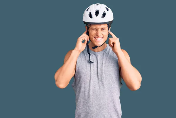 자전거 헬멧을 손가락으로 가리고 시끄러운 소리에 짜증나는 표정을 잘생긴 — 스톡 사진