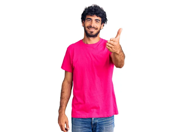 英俊的年轻人 卷曲的头发 身穿休闲的粉色T恤 微笑友善地握手致意和欢迎 成功的商业 — 图库照片