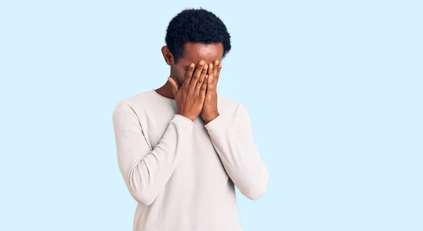 非洲英俊男子身穿休闲地冬季毛衣 脸上挂着忧郁的表情 一边哭一边用手捂住脸 抑郁症的概念 — 图库照片