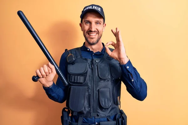 Üniforma Giyen Yakışıklı Bir Polis Memuru Sarı Arka Planda Baston — Stok fotoğraf