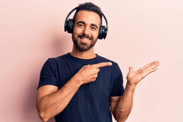 Young Hispanic Man Listening Music Using Headphones Amazed Smiling Camera — Stock Photo, Image
