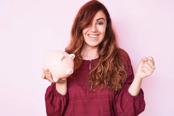 Joven Hermosa Mujer Sosteniendo Alcancía Gritando Orgulloso Celebrando Victoria Éxito —  Fotos de Stock