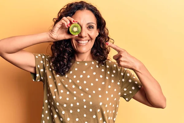 Mulher Bonita Meia Idade Segurando Kiwi Sobre Olho Sorrindo Feliz — Fotografia de Stock