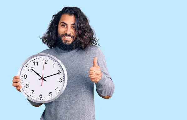 Jovem Árabe Homem Segurando Grande Relógio Sorrindo Feliz Positivo Polegar — Fotografia de Stock