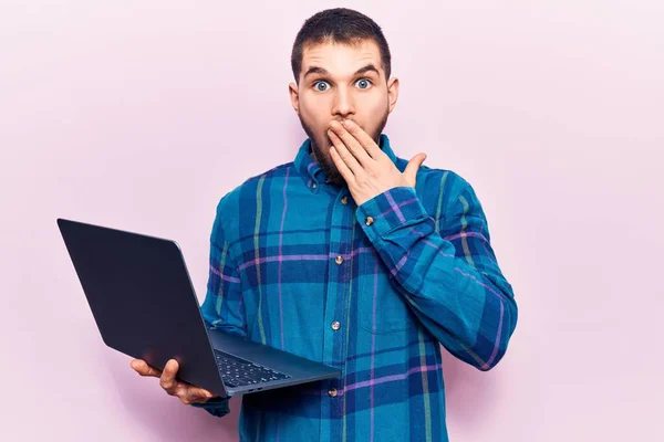若いハンサムな男が手で口をカバーノートパソコンを使用して作業し ショックを受け 間違いを恐れている 驚きの表情 — ストック写真