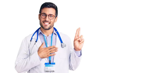 Jovem Hispânico Vestindo Uniforme Médico Estetoscópio Sorrindo Jurando Com Mão — Fotografia de Stock