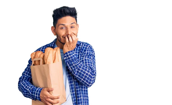 Guapo Joven Latinoamericano Sosteniendo Bolsa Papel Con Pan Riéndose Riéndose —  Fotos de Stock