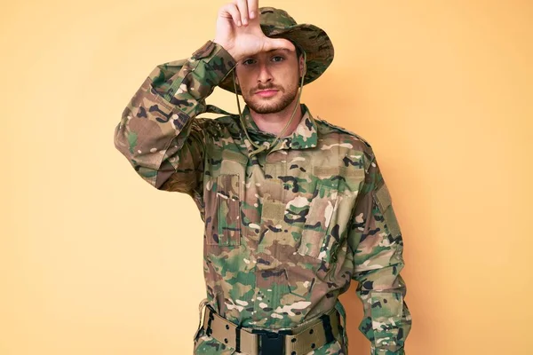 額に指で人をからかう制服姿の若いですCaucasian男ありますカモフラージュ軍隊制服を身に着けています — ストック写真