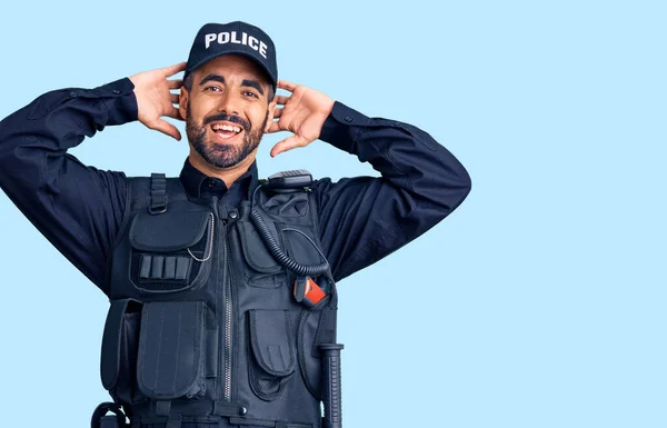 Joven Hispano Vistiendo Uniforme Policía Relajándose Estirándose Brazos Manos Detrás —  Fotos de Stock