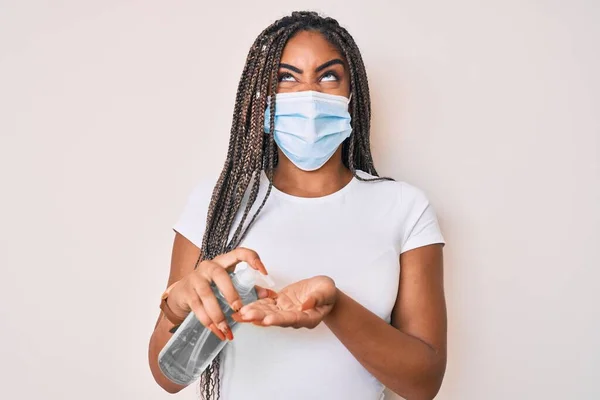 Νεαρή Αφροαμερικανή Γυναίκα Κοτσίδες Που Φορούσε Ιατρική Μάσκα Χρησιμοποιώντας Απολυμαντικό — Φωτογραφία Αρχείου