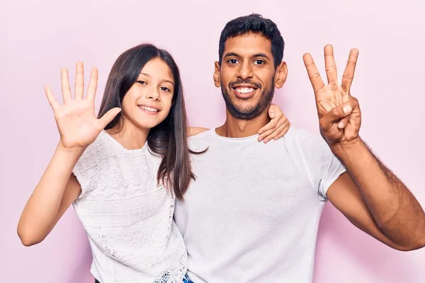 年轻的父亲和女儿穿着休闲装 手指点点八号 面带微笑 自信而快乐 — 图库照片