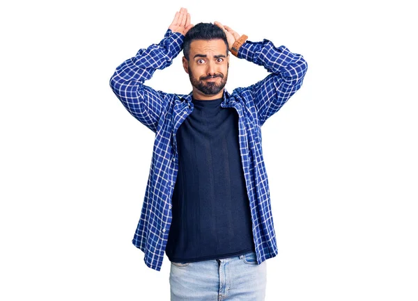 Gündelik kıyafetler giyen, tavşan kulağı yapan, avuçlarıyla alaycı ve şüpheci görünen genç İspanyol bir adam. Paskalya tavşanı konsepti. 