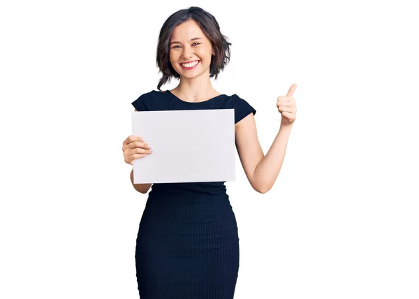 Menina Bonita Jovem Segurando Banner Vazio Branco Sorrindo Feliz Positivo — Fotografia de Stock