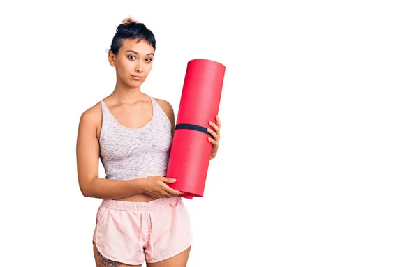 Junge Frau Mit Yogamatte Und Nüchternem Gesichtsausdruck Wirkt Selbstbewusst — Stockfoto