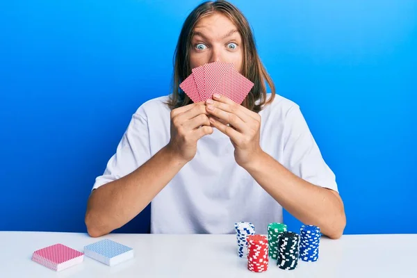 Uzun Saçlı Kumarda Poker Oynayan Yakışıklı Beyaz Adam Kartlarla Yüzünü — Stok fotoğraf