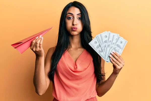 Beautiful Hispanic Woman Holding Paper Plane Dollars Puffing Cheeks Funny — Stock Photo, Image