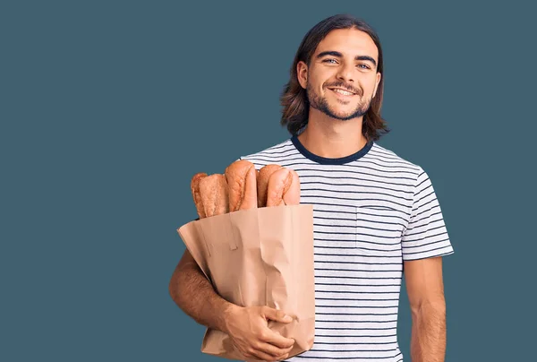 Jovem Homem Bonito Segurando Saco Papel Com Pão Olhando Positivo — Fotografia de Stock