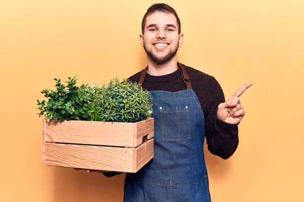 Young Handsome Man Wearing Gardener Apron Holding Pant Pot Smiling — Stock Photo, Image