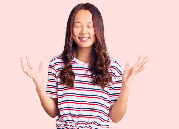 Genç, güzel Çinli kız, gündelik kıyafetler giyip başarıyı kutluyor. Kolları havada, gözleri kapalı, heyecanlı çığlıklar atıyorlar. Kazanan konsept 