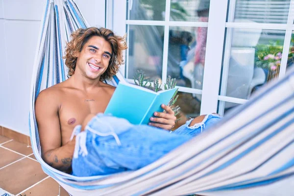 Ung Latinamerikansk Man Avslappnad Läsa Bok Som Ligger Hängmattan Terrassen — Stockfoto