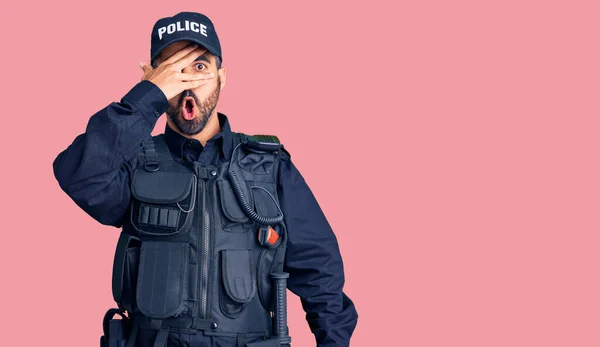 Jovem Hispânico Vestindo Uniforme Policial Espreitando Choque Cobrindo Rosto Olhos — Fotografia de Stock