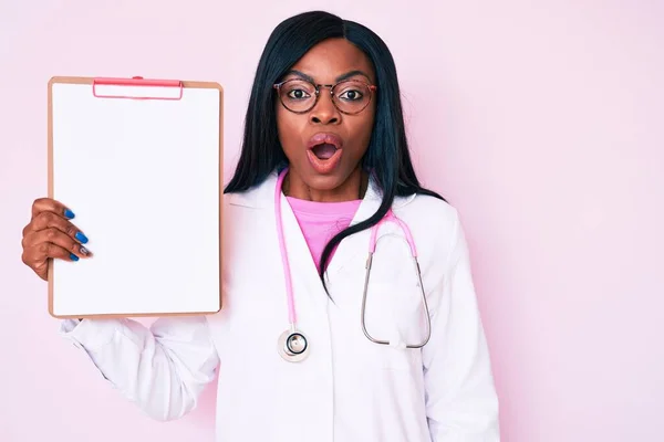 Young African American Woman Wearing Doctor Stethoscope Holding Clipboard Scared — Stock Photo, Image