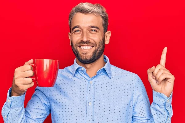 Joven Hombre Rubio Guapo Con Barba Bebiendo Jarra Roja Café — Foto de Stock