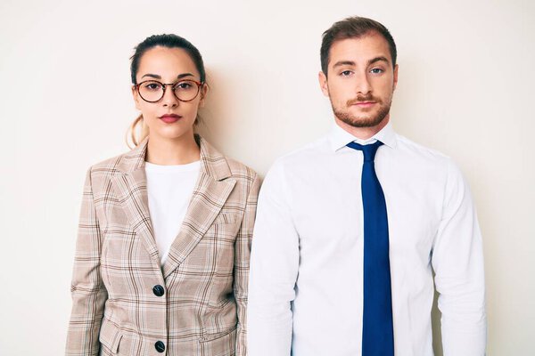 Красивая пара в деловой одежде, расслабленная с серьезным выражением лица. простой и естественный взгляд на камеру. 