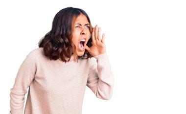 Balıkçı yaka kazak giyen genç, güzel, melez bir kadın avaz avaz bağırıyor ve avaz avaz bağırıyor. iletişim konsepti. 